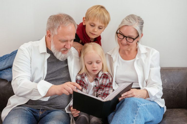 Des grands-parents et leurs petits-enfants regardent un album de photos